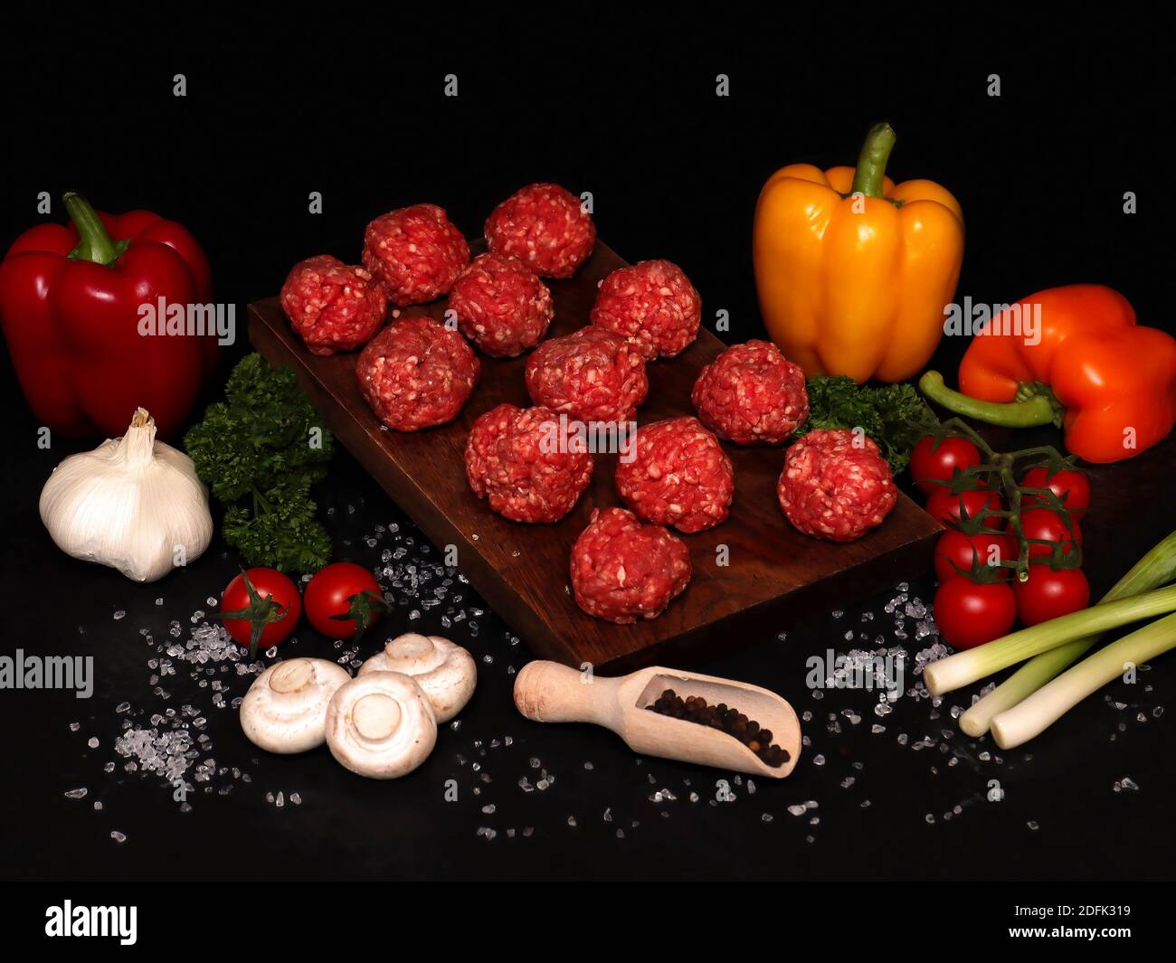 palline di topi di manzo su un asse di legno con ingredienti per Bolognese Foto Stock