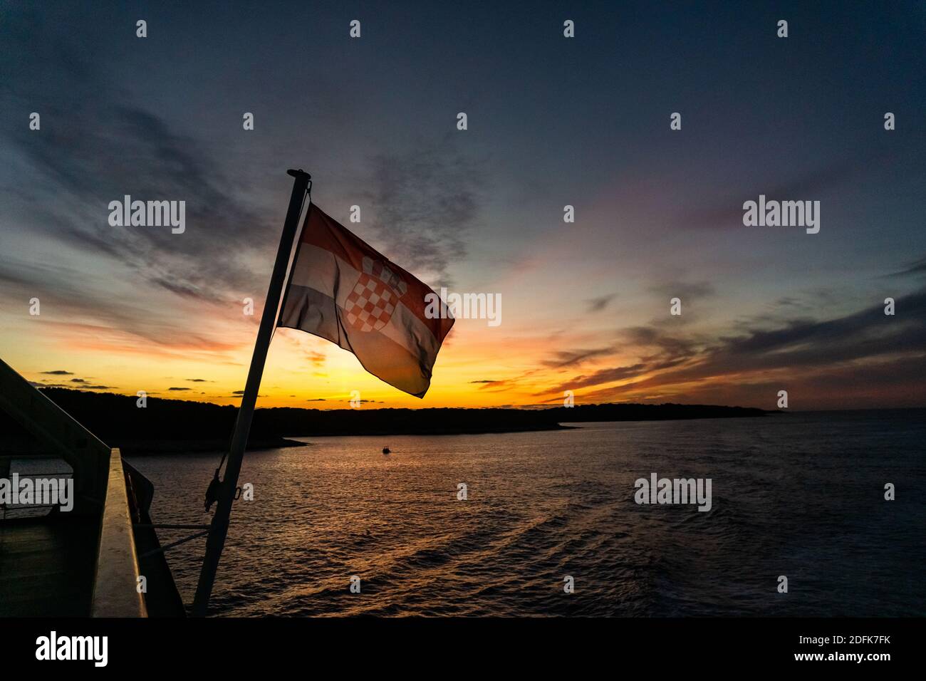 Bandiera della Croazia su una barca a vela sul mare al tramonto colorato con le nuvole Foto Stock