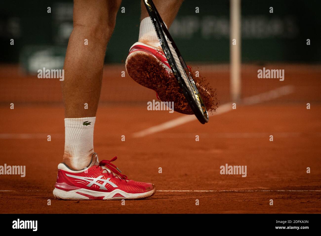 Novak Djokovic di Serbia strinse la sua racchetta sulle sue scarpe per  rimuovere l'argilla dall'anima durante la quarta partita dei Singles degli  uomini contro Karen Khachanov di Russia il 9° giorno del