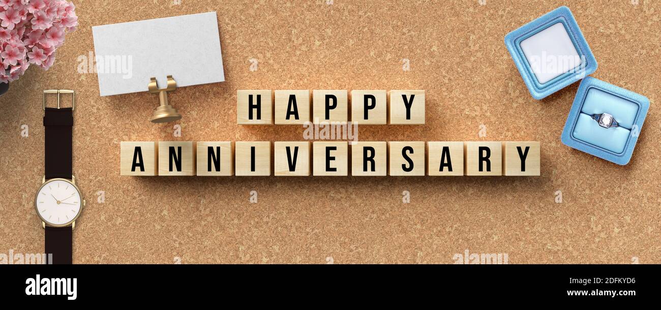 Cubetti con messaggio BUON ANNIVERSARIO con regali e decorazione floreale su sfondo concreto Foto Stock