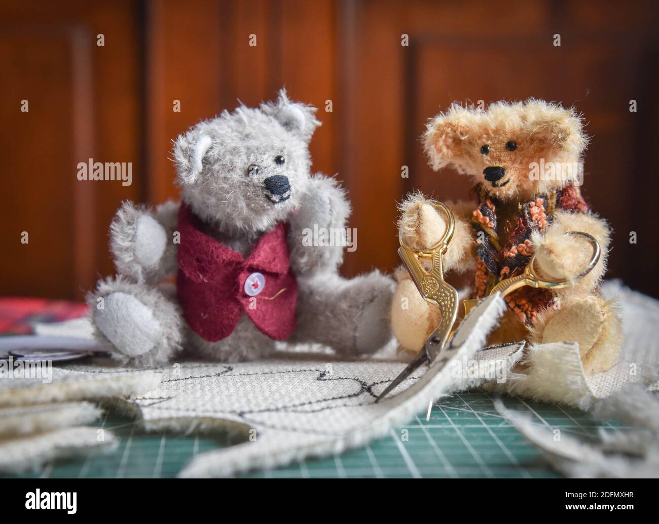 Due orsacchiotti tagliano un modello per cucire un altro giocattolo orsacchiotto Foto Stock