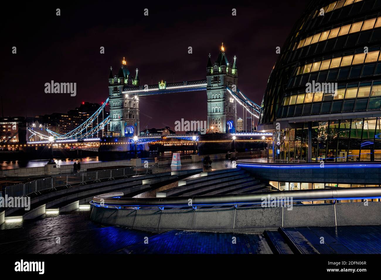 Londra, Regno Unito - Gennaio 2020: Ponte della Torre, e passerete davanti all'anfiteatro Scoop con il moderno edificio del Municipio. Illuminare le strade della città a Foto Stock