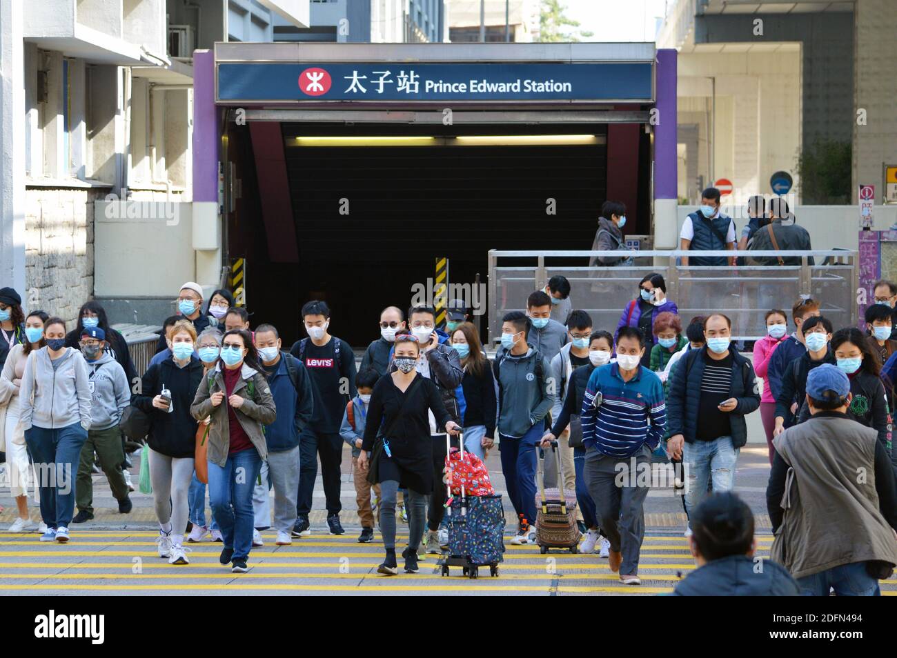 I pedoni di Hong Kong attraversano la strada indossando maschere durante la pandemia di Covid-19, dicembre 2020 Foto Stock