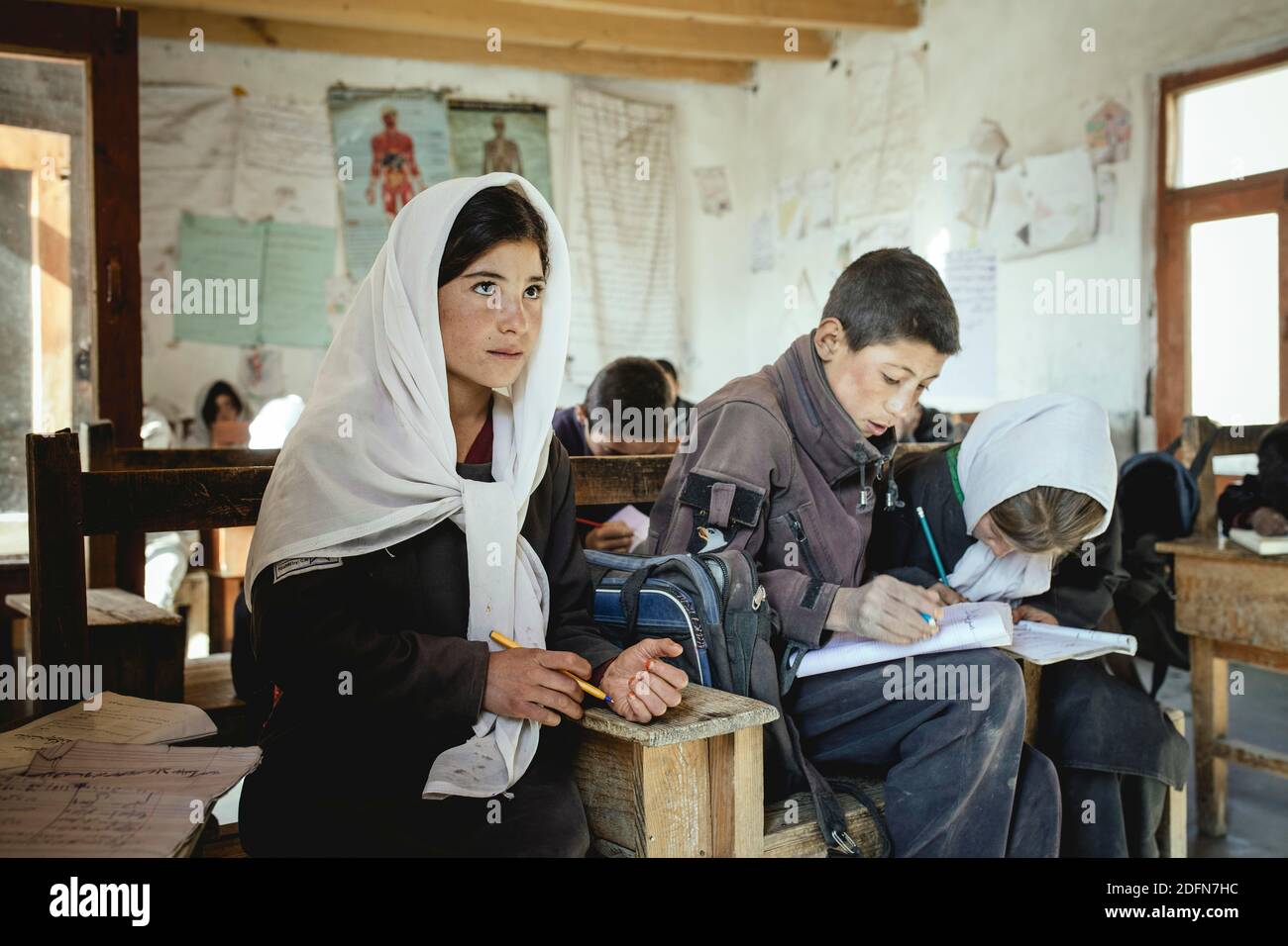 Tre alunni in un banco scolastico, in classe, Potokh Primary School, Potokh, Wakhan Corridor, Afghanistan Foto Stock