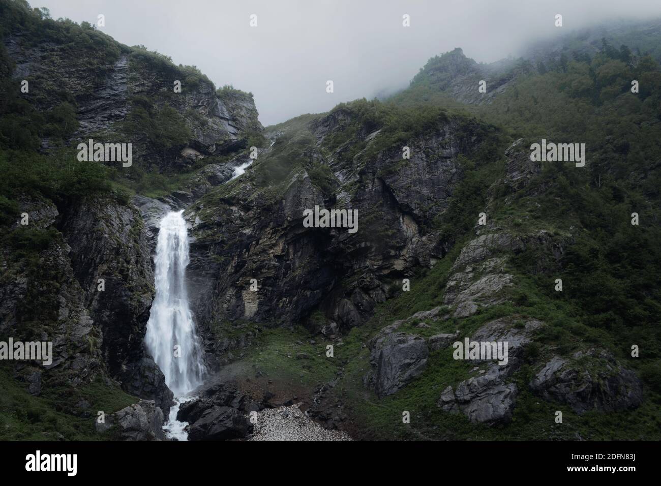 Cascata Moody tra le montagne verdi coperte di nuvole Foto Stock
