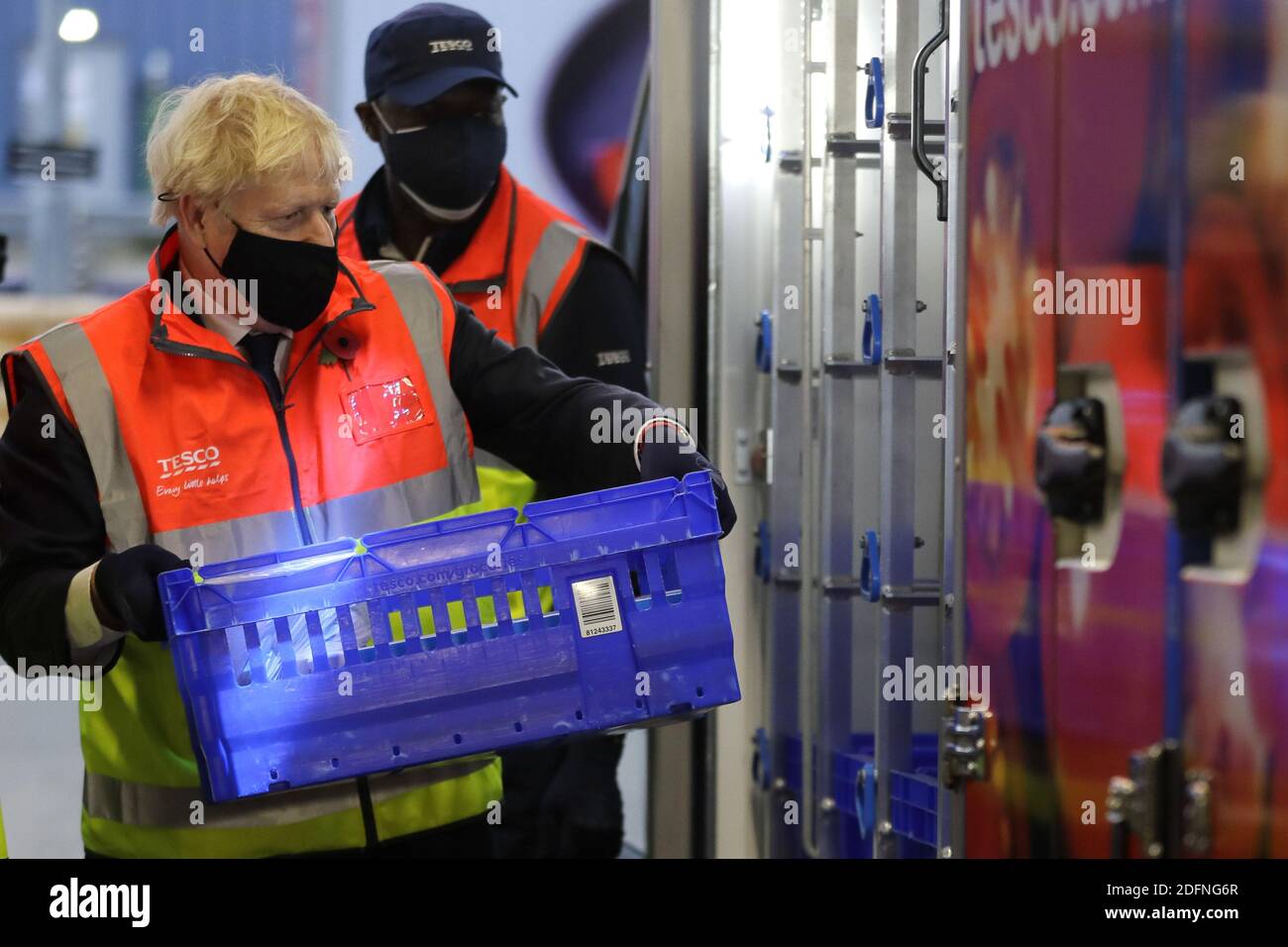 File photo datato 11/11/20 del primo Ministro Boris Johnson che carica un furgone con un cestino di shopping durante una visita al Centro di distribuzione Tesco Erith nel sud-est di Londra. Il 13 dicembre 2020 ricorre il primo anniversario della vittoria elettorale generale del sig. Johnson. Foto Stock