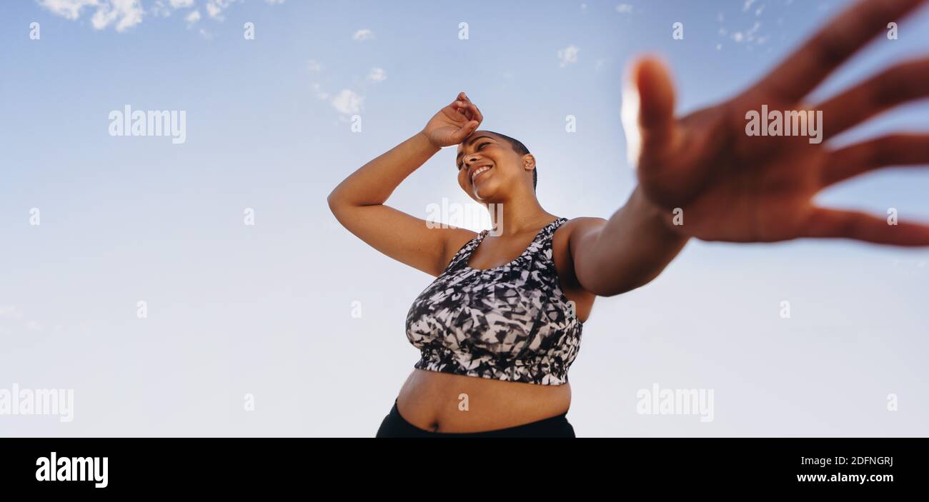 POV girato di una donna che si rilassa dopo l'allenamento. Più taglia femmina che prende la pausa dopo l'allenamento all'aperto. Foto Stock