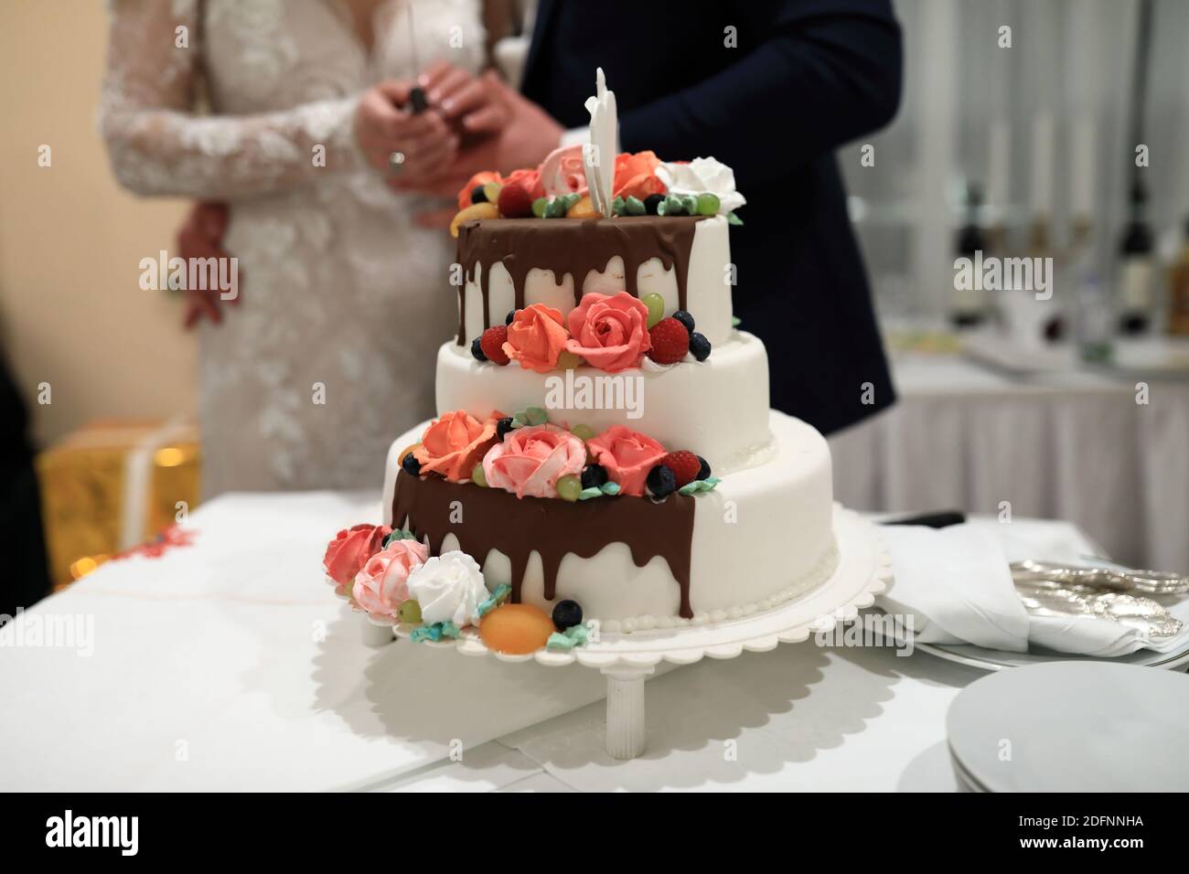 Vista della torta nuziale sullo sfondo degli sposi novelli Foto Stock