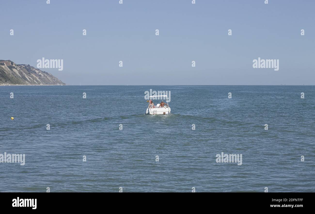 Una coppia anziana salpa dal porto di Pesaro con una barca bianca per le vacanze estive (Marche, Italia, Europa) Foto Stock