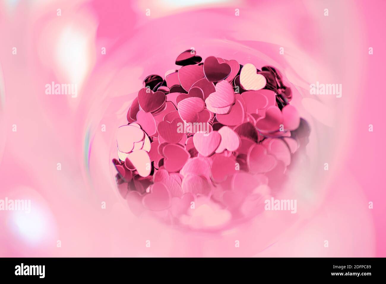 Cuori rossi sono sparsi in un bicchiere. Il giorno di San Valentino concetto Foto Stock