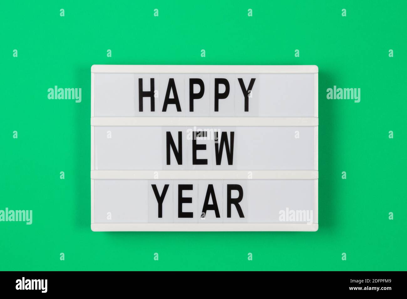 Felice anno nuovo testo in una casella di luce su verde sfondo Foto Stock