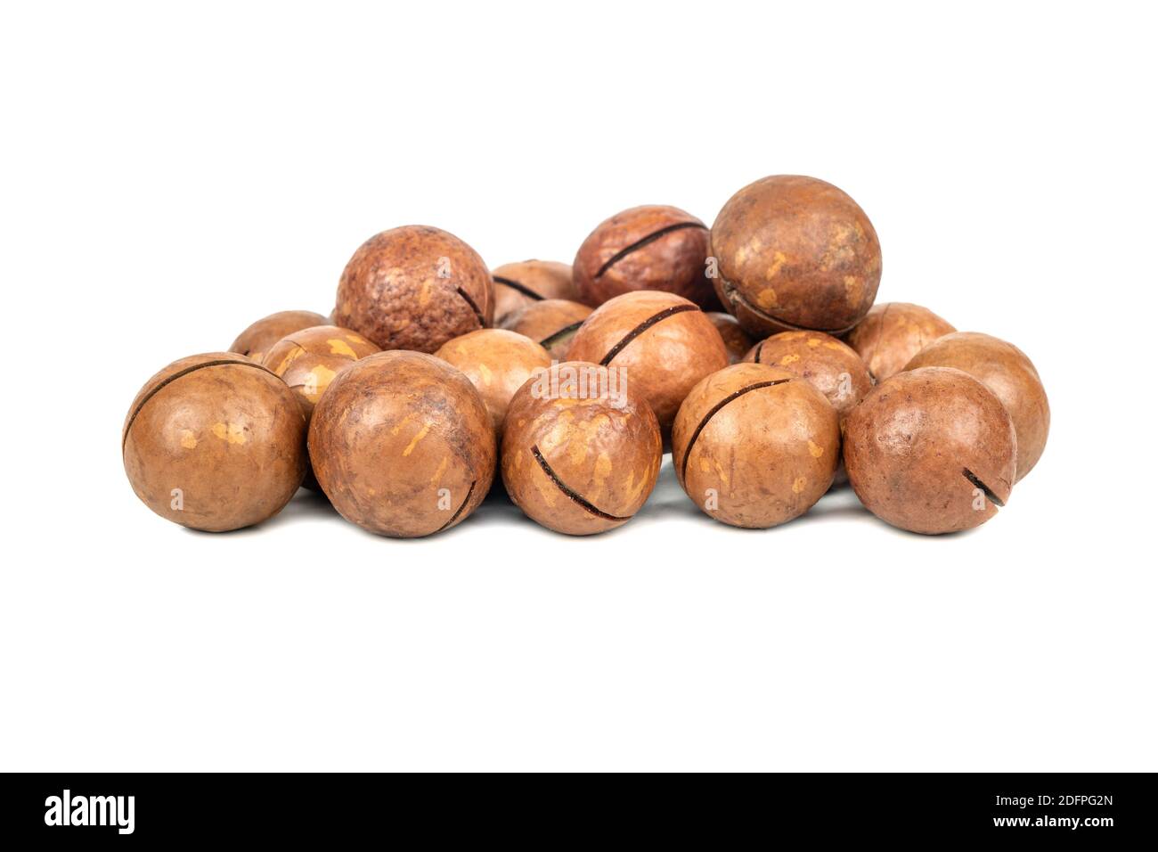 Pila di noci di macadamia in un guscio su un bianco sfondo Foto Stock