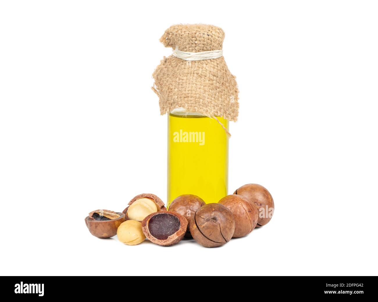 Noci di macadamia con olio in una bottiglia su un bianco sfondo Foto Stock