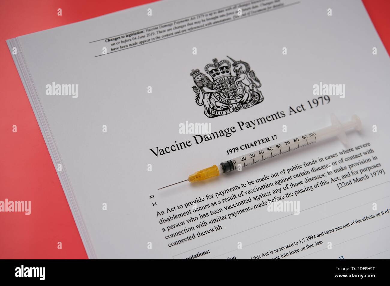 Stafford, Regno Unito - 6 dicembre 2020: Legge del governo britannico sui danni da vaccino e una siringa. Foto Stock