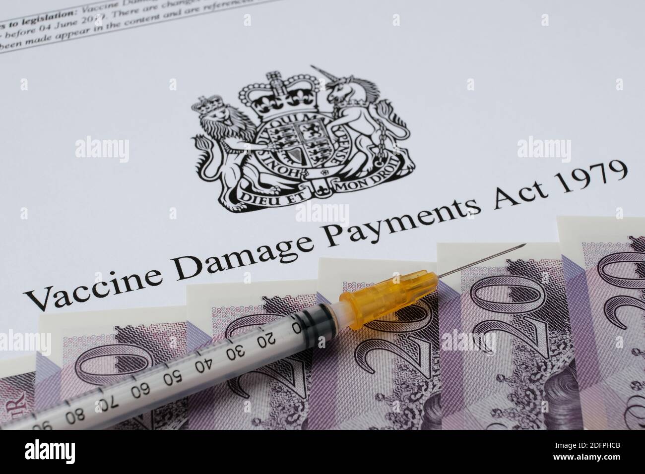 Stafford, Regno Unito - 6 dicembre 2020: UK Government's Vaccine Damage Payments Act. Immagine ravvicinata di denaro e siringa. Foto Stock