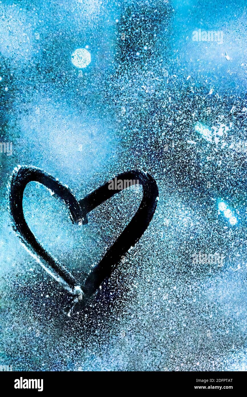 Un cuore dipinto su vetro congelato con sfondo blu Foto Stock