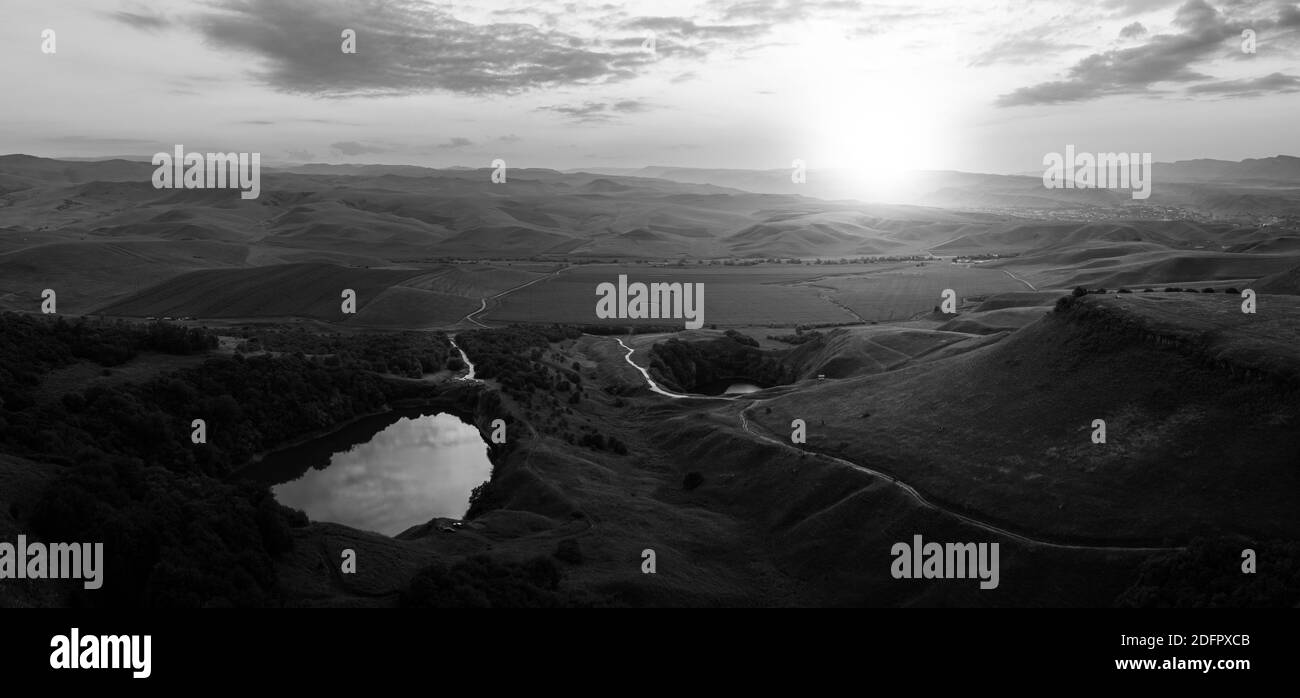Tramonto ai piedi delle colline, lago pittoresco e tramonto sulle colline. Foto Stock