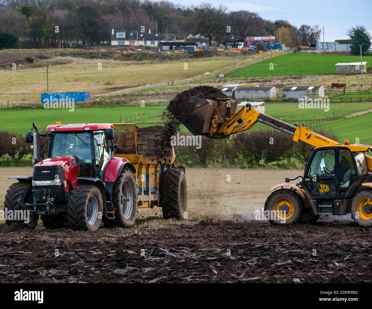 Rimorchio per trattore di carico JCB con liquame o concime in campo arato, East Lothian, Scozia, Regno Unito Foto Stock