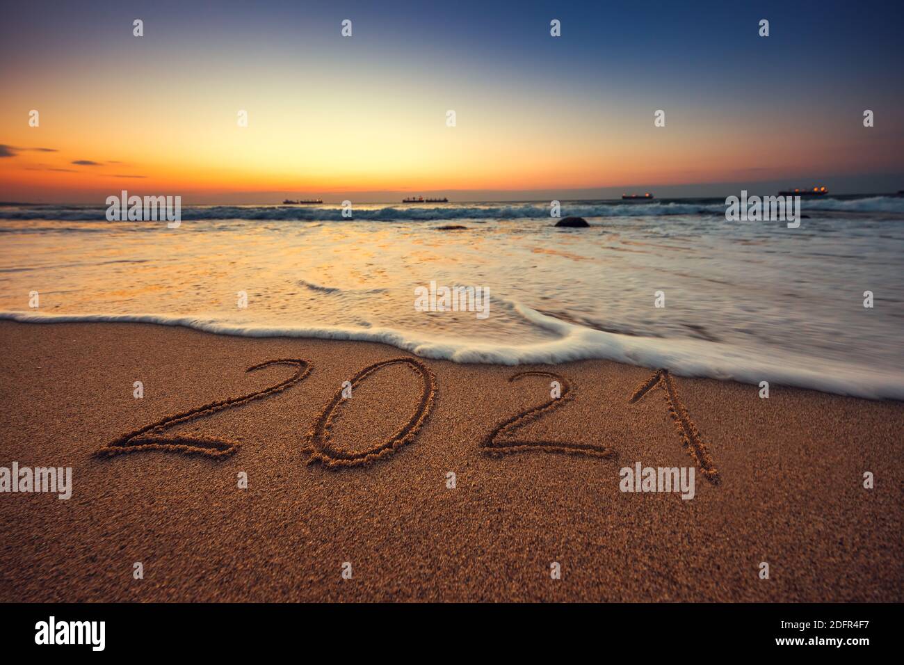 Felice anno nuovo 2021 concetto, scritta sulla spiaggia. Alba mare. Foto Stock