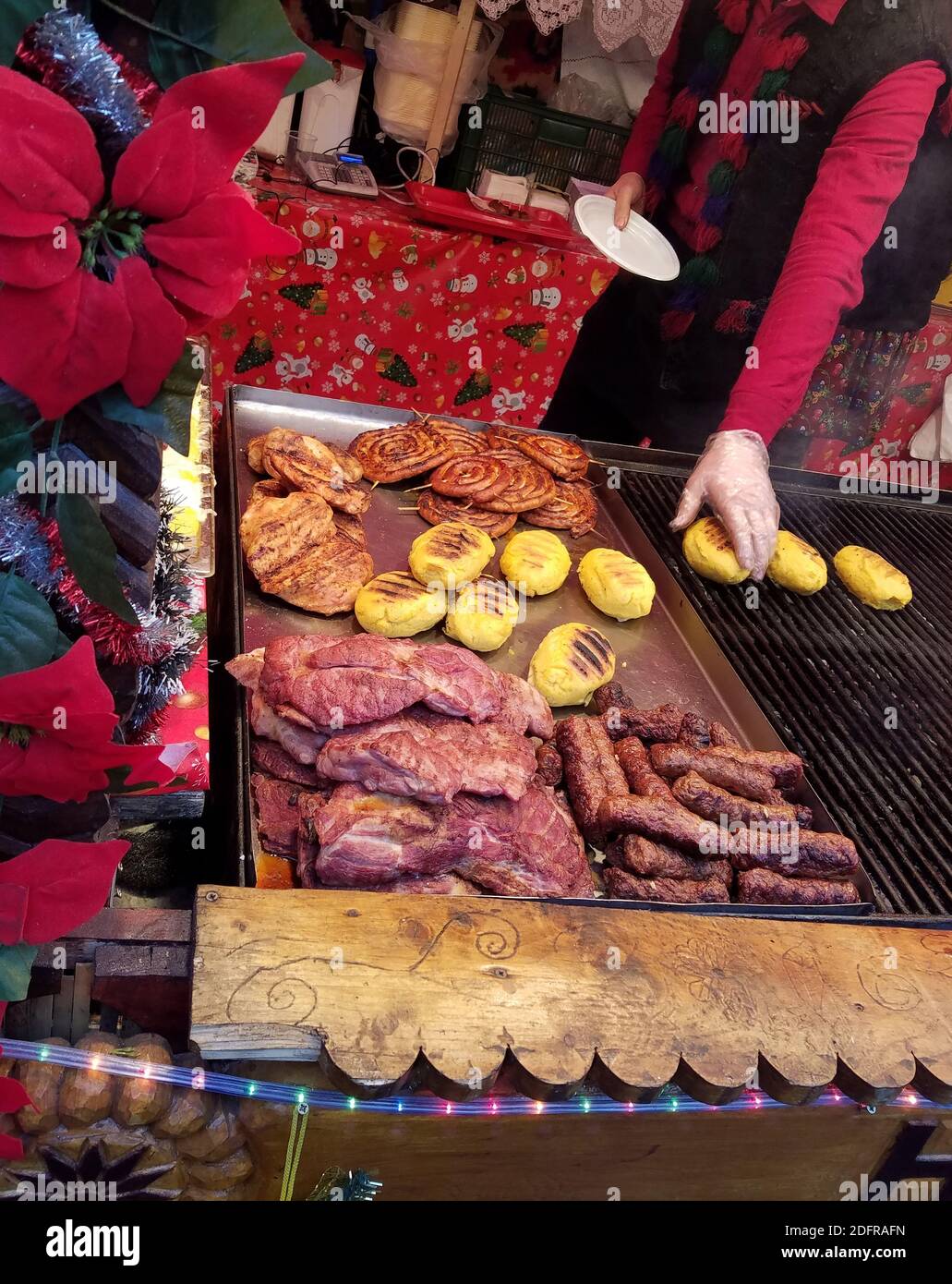 TIMISOARA, ROMANIA - 20 DICEMBRE 2016: Polenta grigliata uomo, salsicce e carni in una fiera di Natale della regione di Maramures in Romania. Foto Stock