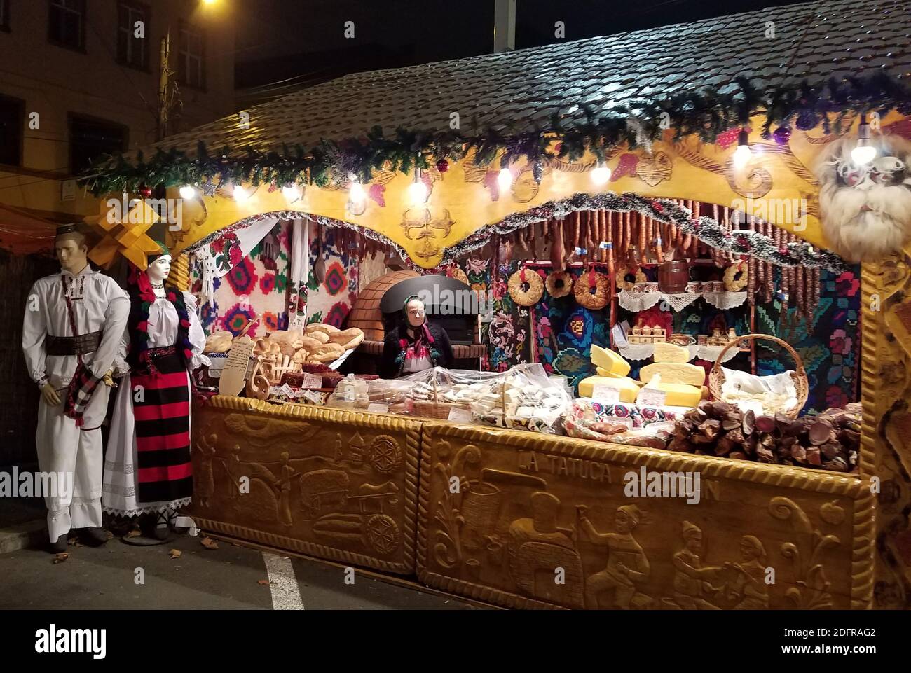 TIMISOARA, ROMANIA - 20 DICEMBRE 2016: Donna tradizionalmente vestita serve in una mostra di Natale di formaggi e carni fatti in casa della regione o Foto Stock