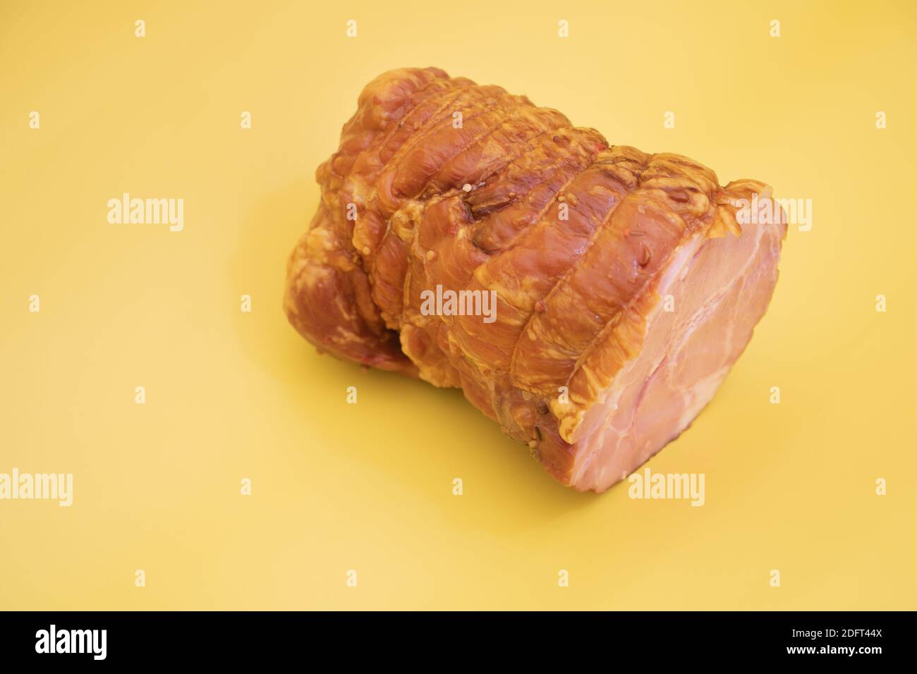 Un pezzo di Salame su sfondo giallo. Foto Stock