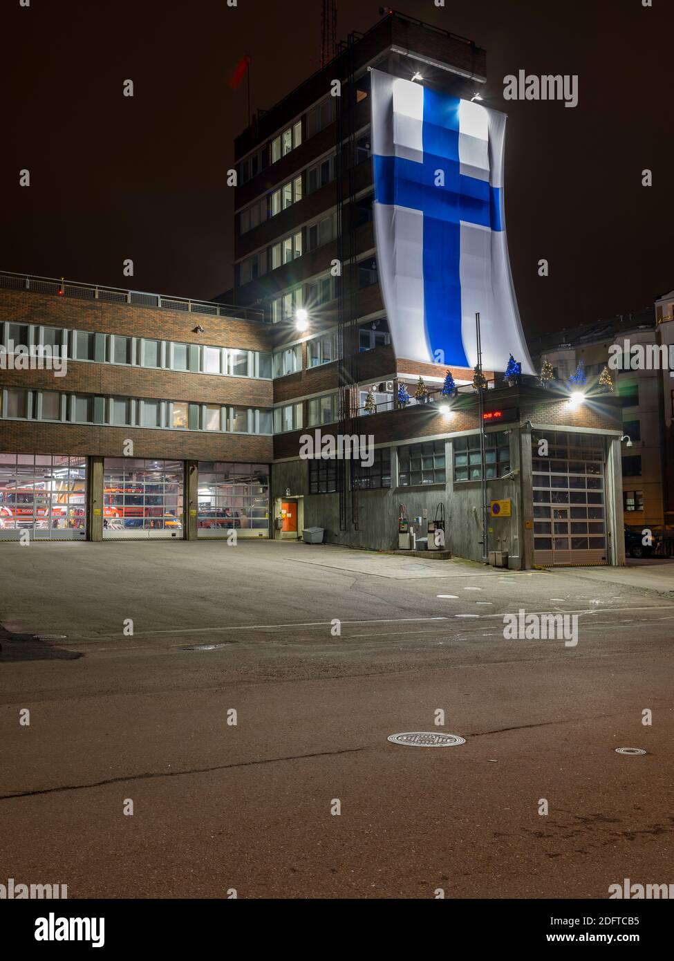 Helsinki / Finlandia - 6 dicembre 2020: Il dipartimento di soccorso e fuoco della città di Helsinki ha celebrato la giornata dell'indipendenza finlandese appeso una bandiera gigante ou Foto Stock
