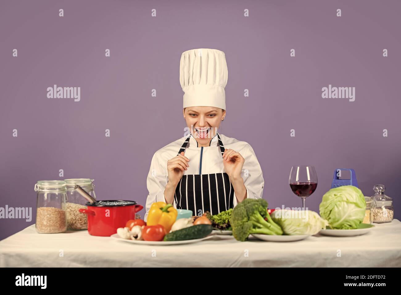 Sia tutto che possiate essere. Lo chef felice cucinando le verdure. Cibo sano e dieta. Casalinga della donna in cappello e grembiule del cuoco. Preparazione fresca. Pieno di vitamina. Naturale e organico. Stile di vita della cucina del ristorante. Foto Stock