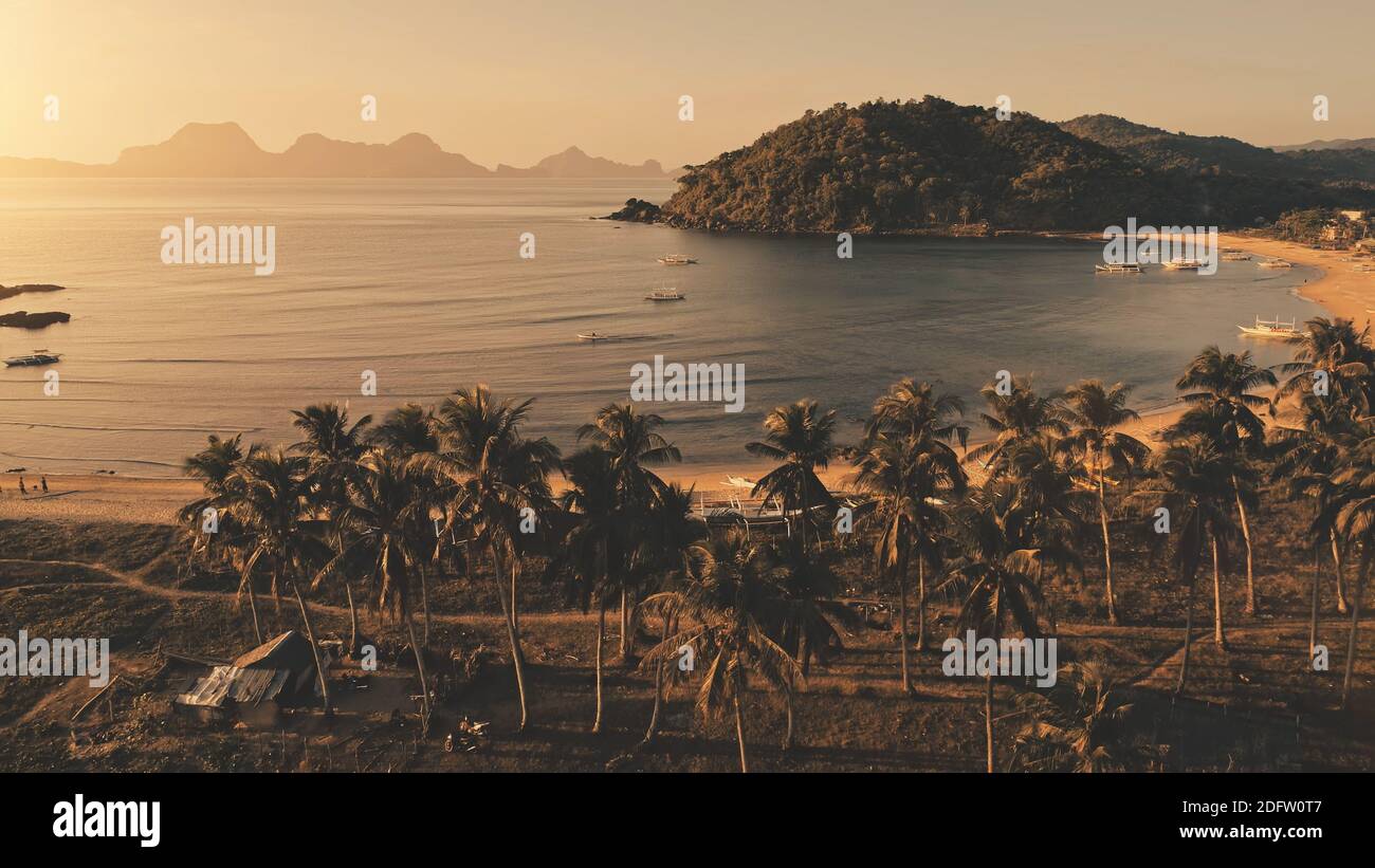 Mare al sole in aereo dell'isola tropicale. Spiaggia di erba con palme. Spiaggia di sabbia a costa oceanica con navi, navi. Estate tropicale nessuno natura paesaggio El Nido Isola, Palawan, Filippine, Asia Foto Stock