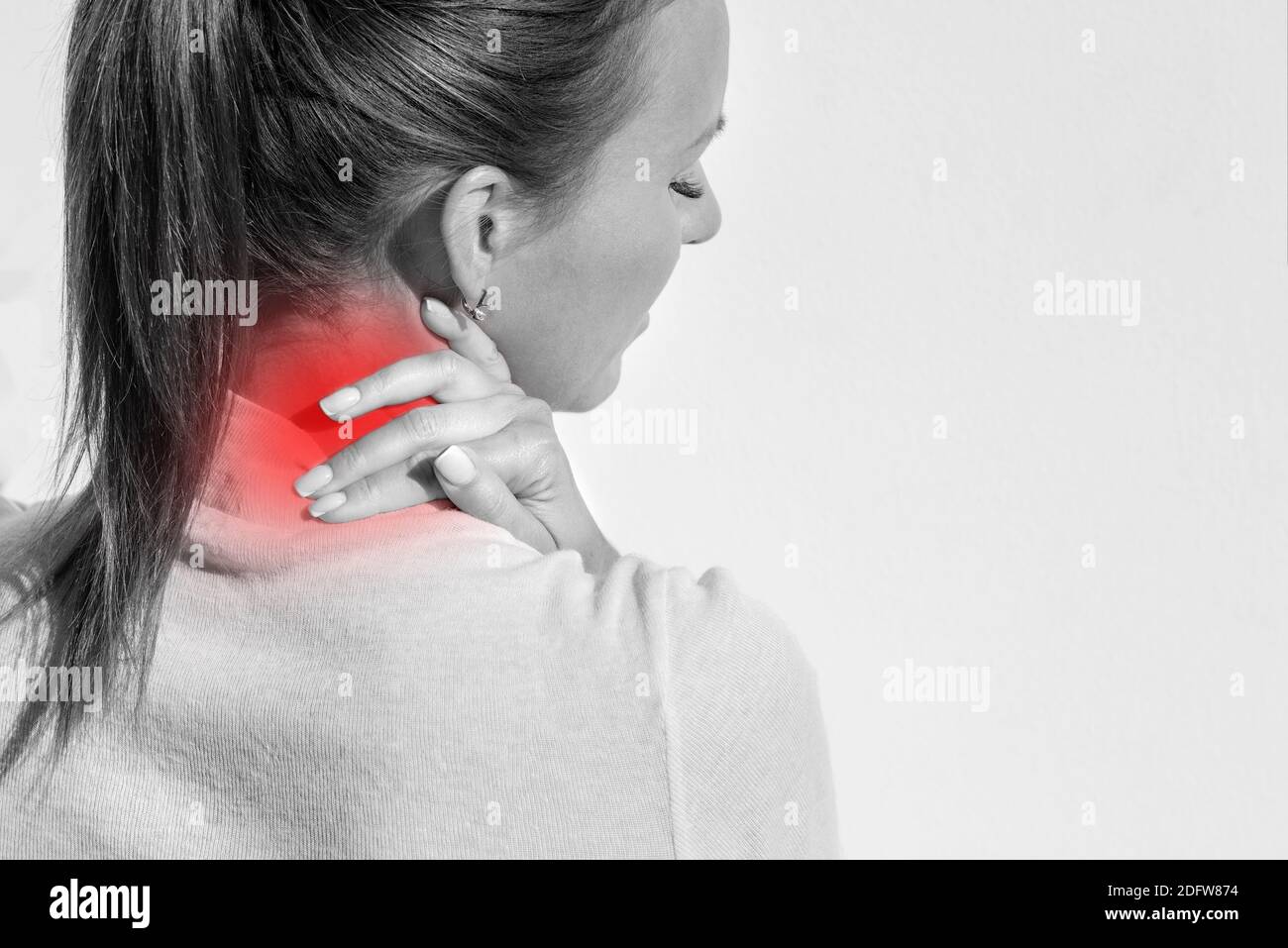 Donna che soffre di dolore al collo e lesioni. Femmina massaggiando il collo. Assistenza sanitaria e concetto medico Foto Stock
