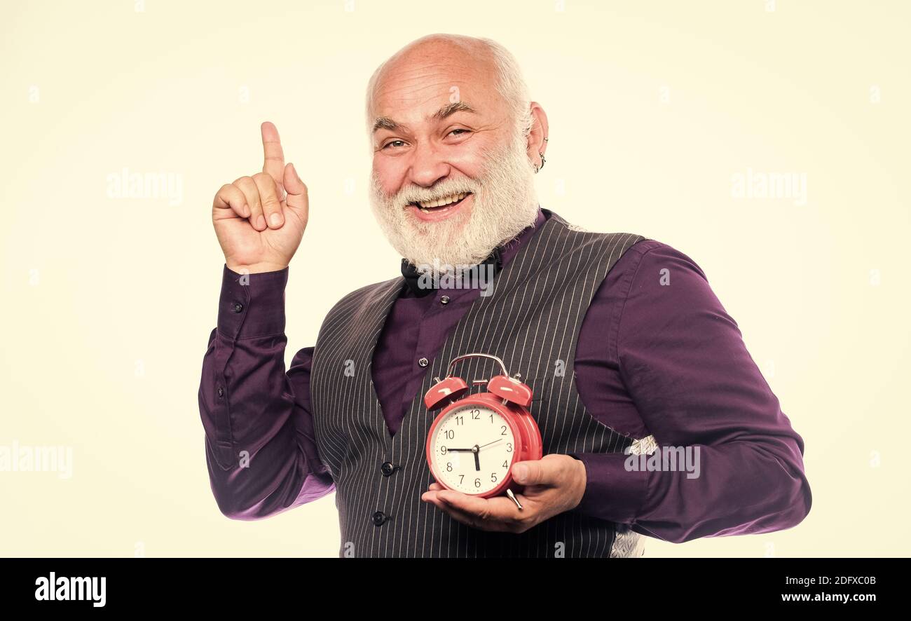 uomo maturo con orologio della barba ora spettacolo. ora e età. Timeeping.  Pensionamento. Guardiere o riparatore di orologi. Gestione del tempo.  Business. Uomo maturo bearded con sveglia. Tenere traccia del tempo Foto