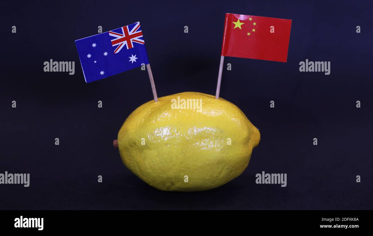 Una bandiera nazionale australiana e cinese attaccata alla pelle di un limone. Rapporti aspri, aspri e aspri tra i due paesi rispetto alle esportazioni commerciali Foto Stock