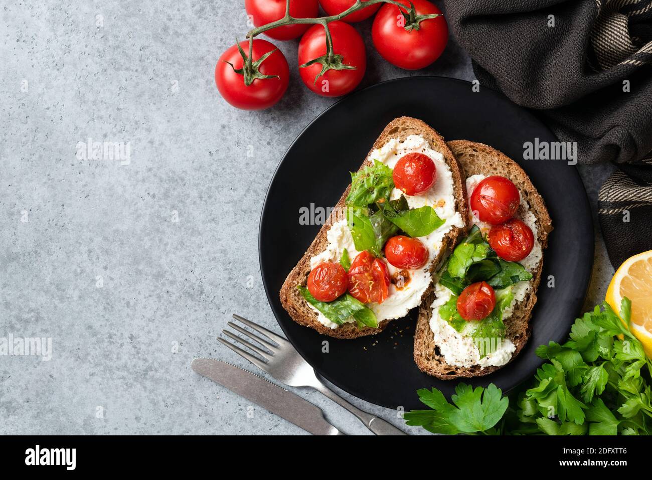 Bruschetta italiana con ricotta e pomodori. Spazio di copia della vista superiore per il testo Foto Stock