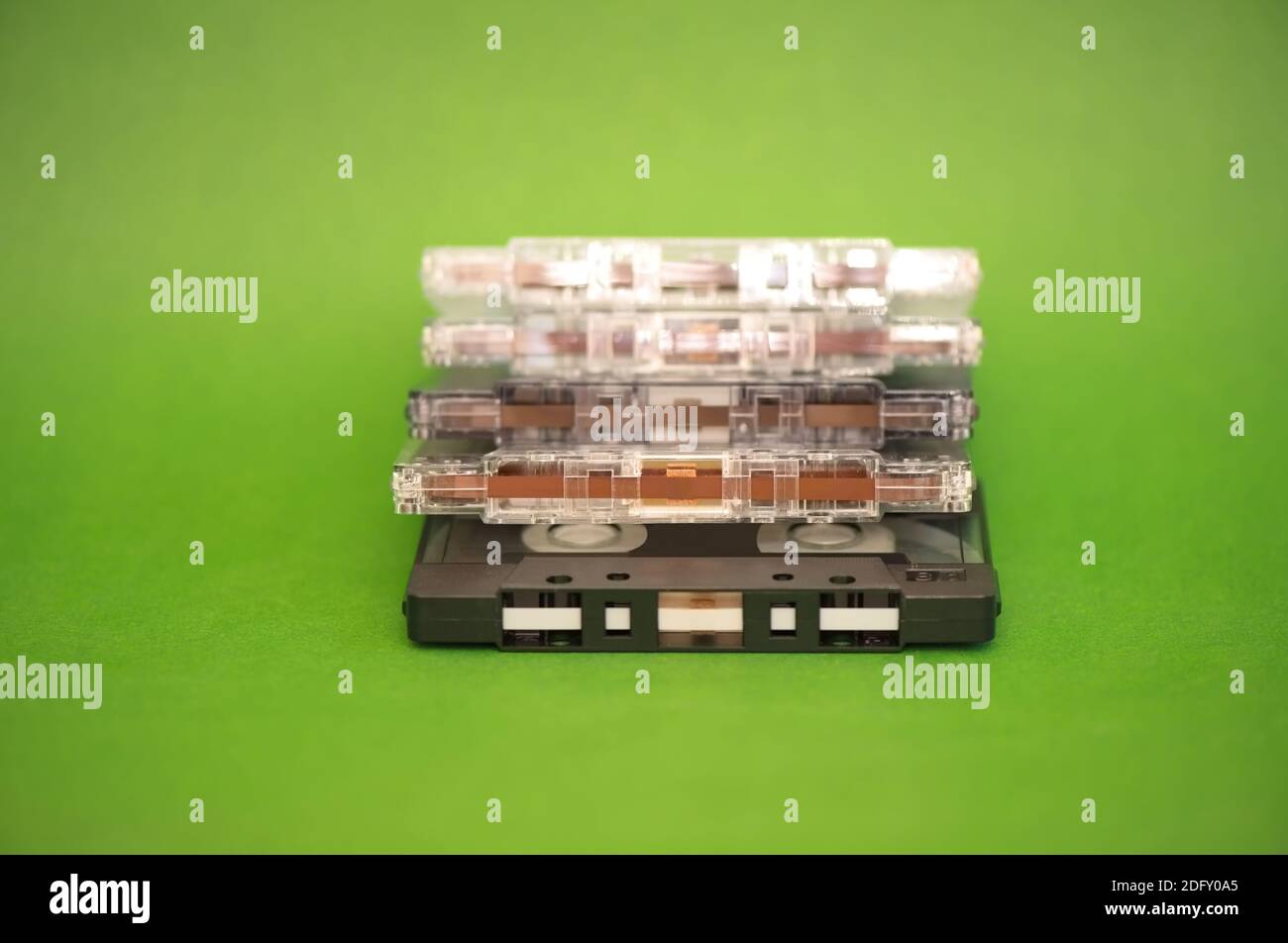 Una pila di cassette audio in plastica su sfondo verde Foto Stock
