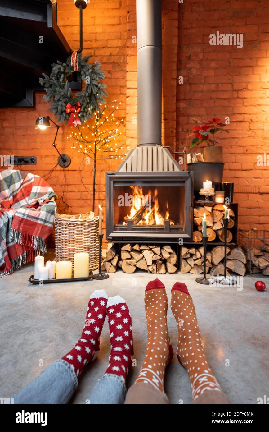 Coppia in calze di Natale vicino al camino a casa. Il concetto di comfort  durante le vacanze invernali e di Capodanno Foto stock - Alamy