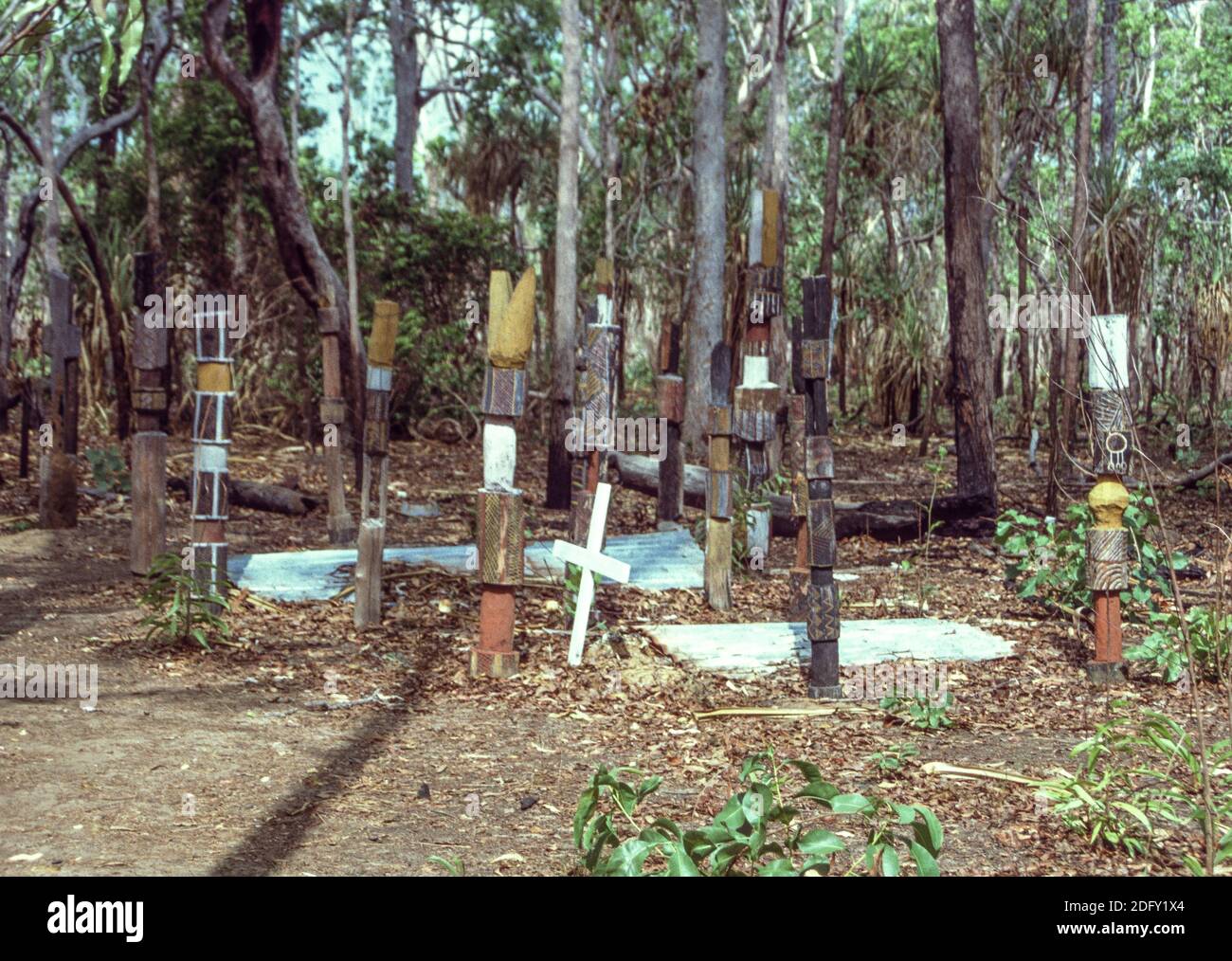 Tomba remota sull'isola di Melville. I pali pukamani si trovano accanto alla croce. Isole Tiwi, territorio del Nord (1994) Foto Stock