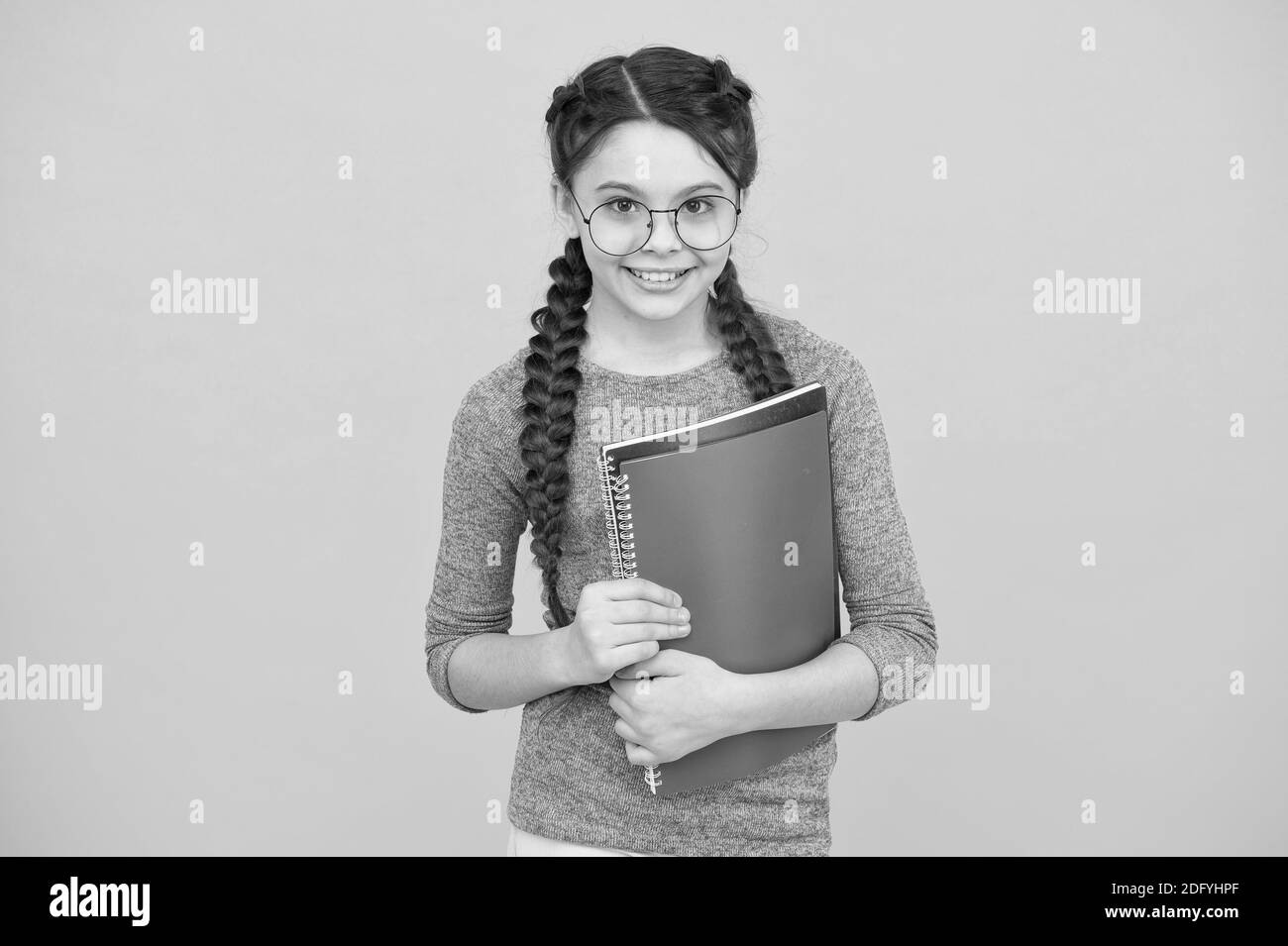 Lezioni private. Concentrarsi sull'istruzione. Scolarizzazione privata. Carino sorridente studentessa. Bambina scolastica. Allievo con le trecce che vanno a scuola. La vita quotidiana della studentessa. Scuola club. Concetto di libreria. Foto Stock