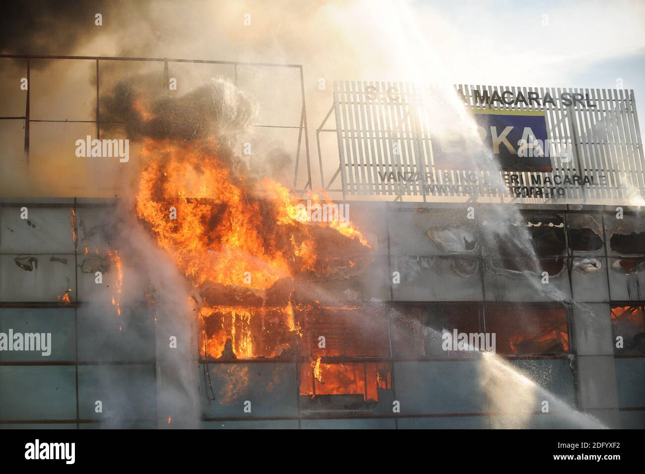 Bucarest, Romania - 7 luglio 2012: I vigili del fuoco cercano di spegnere le fiamme che hanno ingollato un edificio. Foto Stock