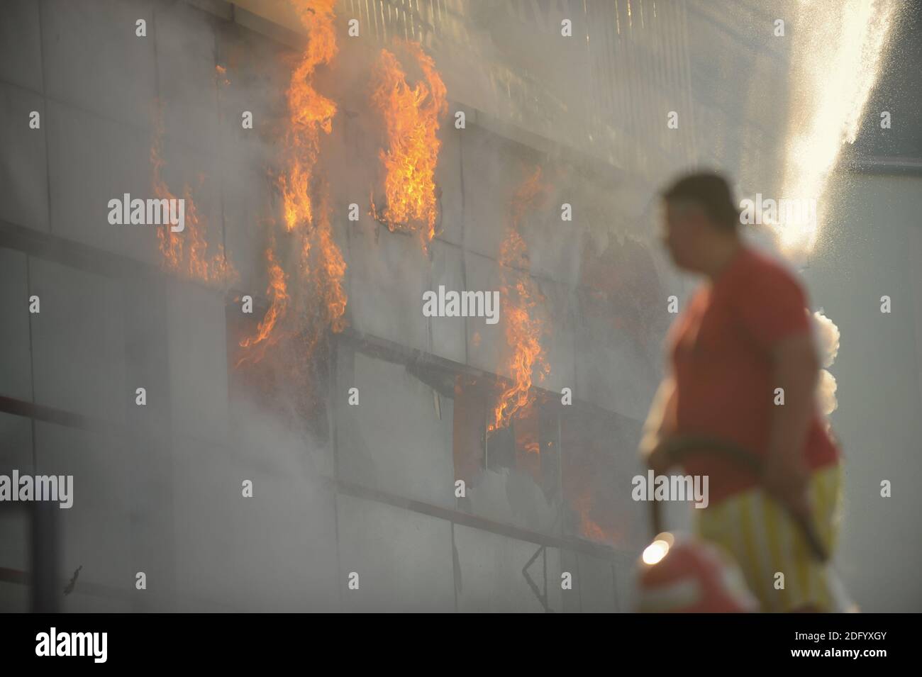 Bucarest, Romania - 7 luglio 2012: I vigili del fuoco cercano di spegnere le fiamme che hanno ingollato un edificio. Foto Stock