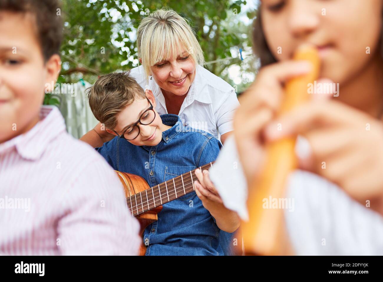 Insegnante e bambini insieme in lezioni di musica nei campi estivi Foto Stock