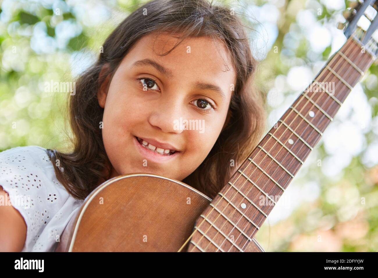 Ragazza musicale con una chitarra nel campo estivo in la classe di chitarra Foto Stock