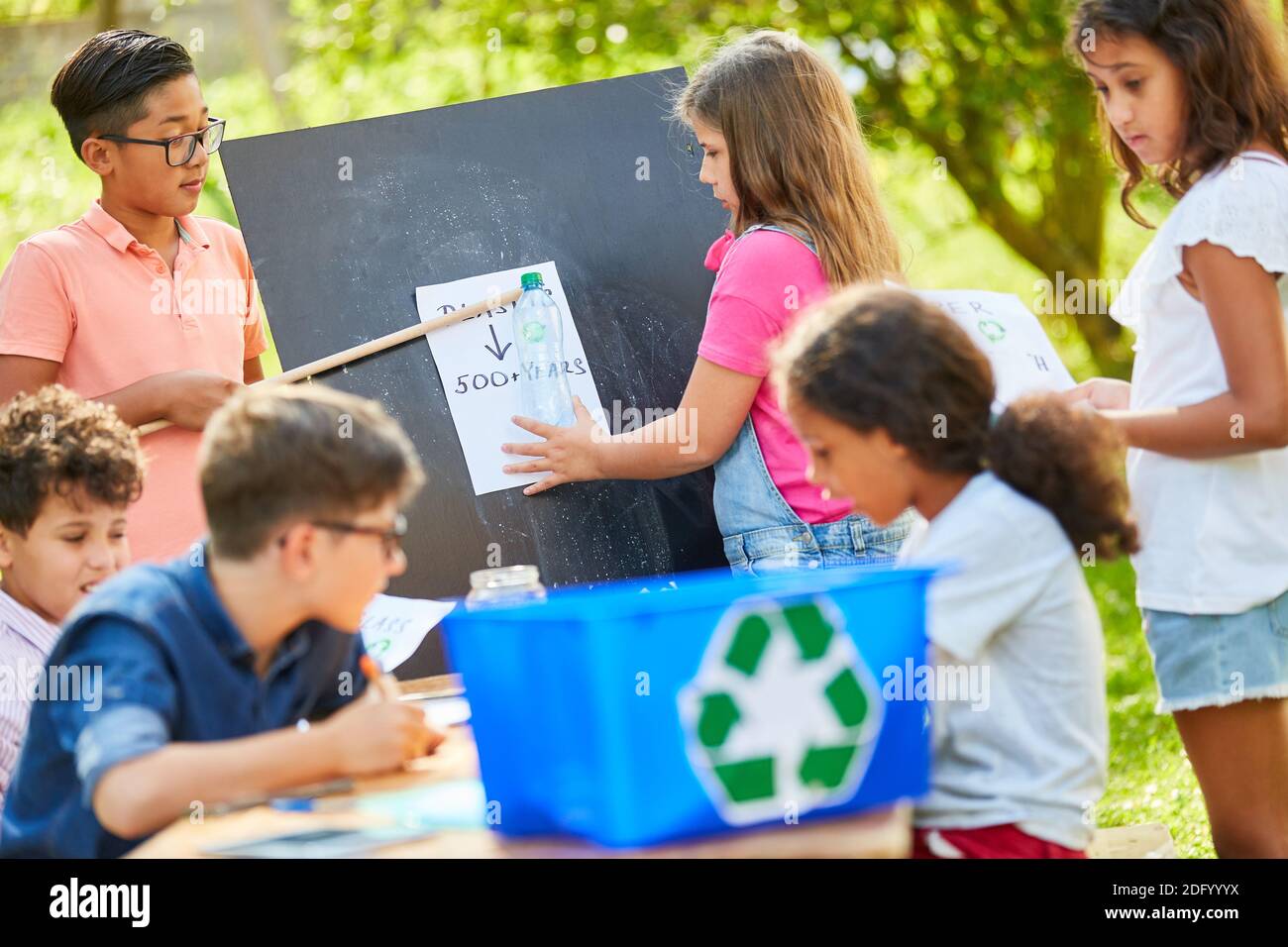 I bambini imparano la protezione ambientale e il riciclaggio in un progetto di ecologia al campo di vacanza Foto Stock