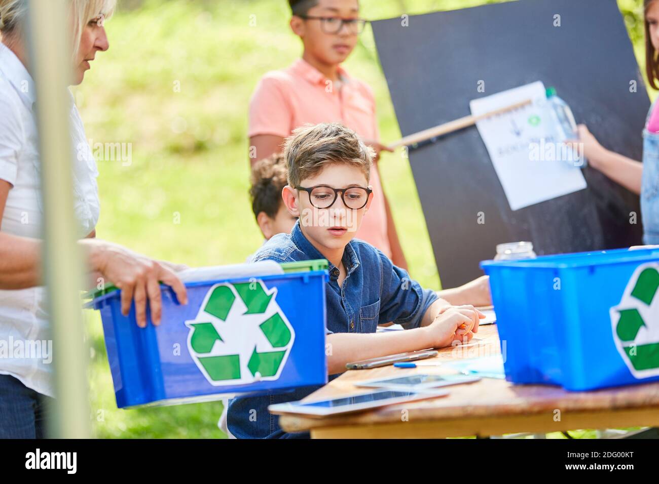 I bambini di gruppo nel campo estivo imparano a conoscere la sostenibilità in il progetto di riciclaggio Foto Stock