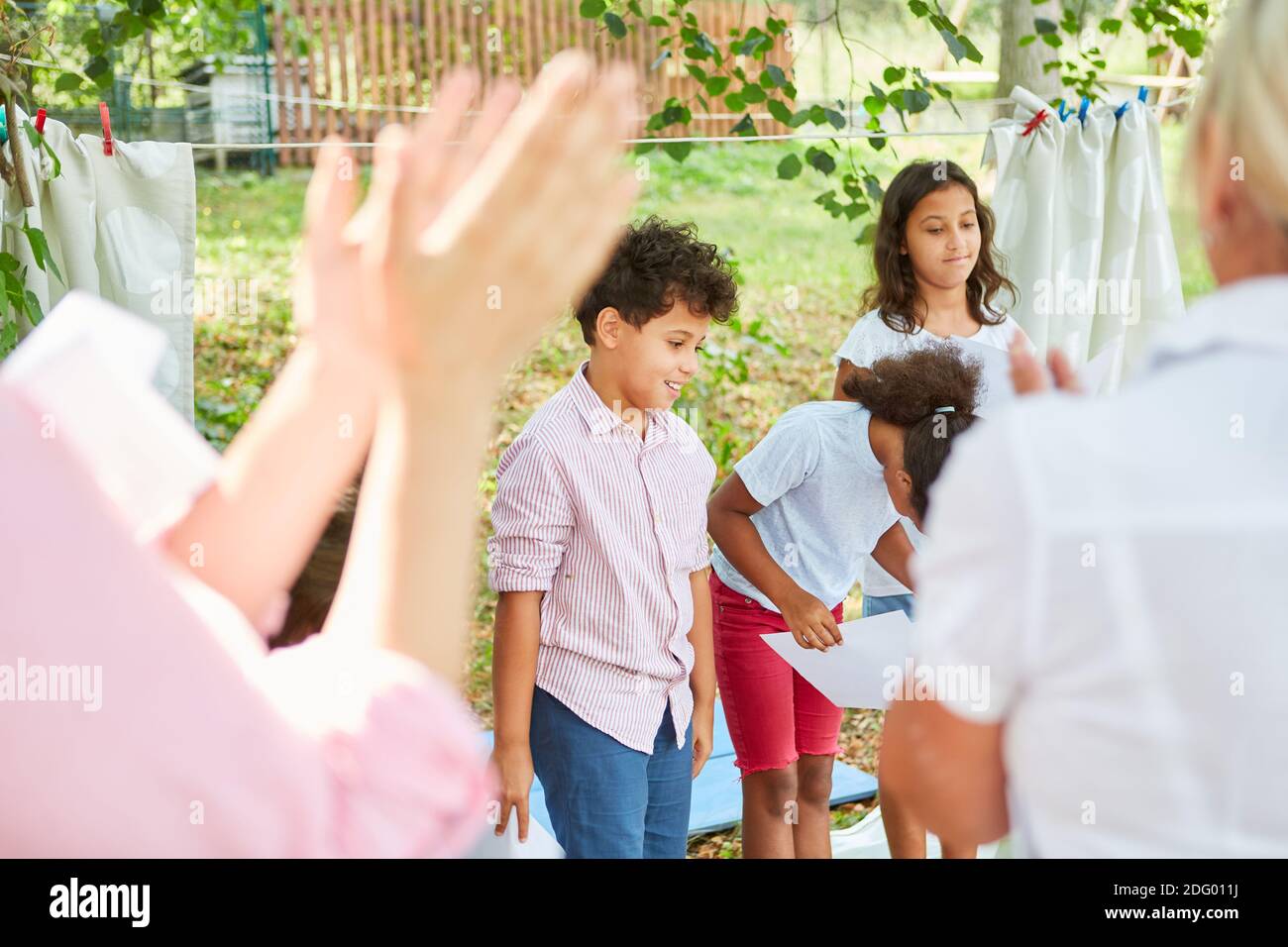 Gli spettatori applaudono alla performance di talent show dei bambini coro nel campo estivo Foto Stock