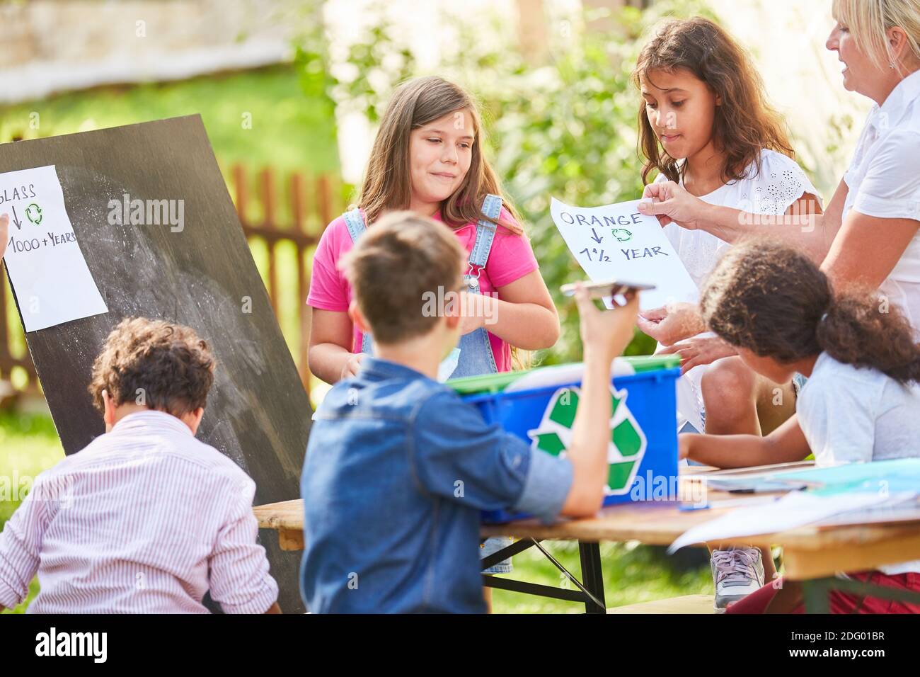 Gruppo dei bambini come ambientalisti volontari in un progetto di riciclaggio a. il campo di vacanza Foto Stock