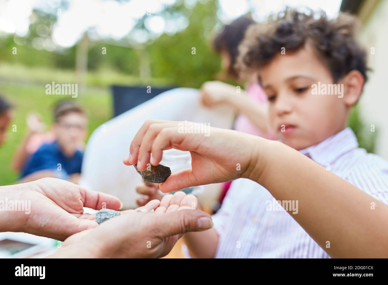 I bambini esaminano pietre e minerali nella classe di storia naturale a. campo estivo Foto Stock