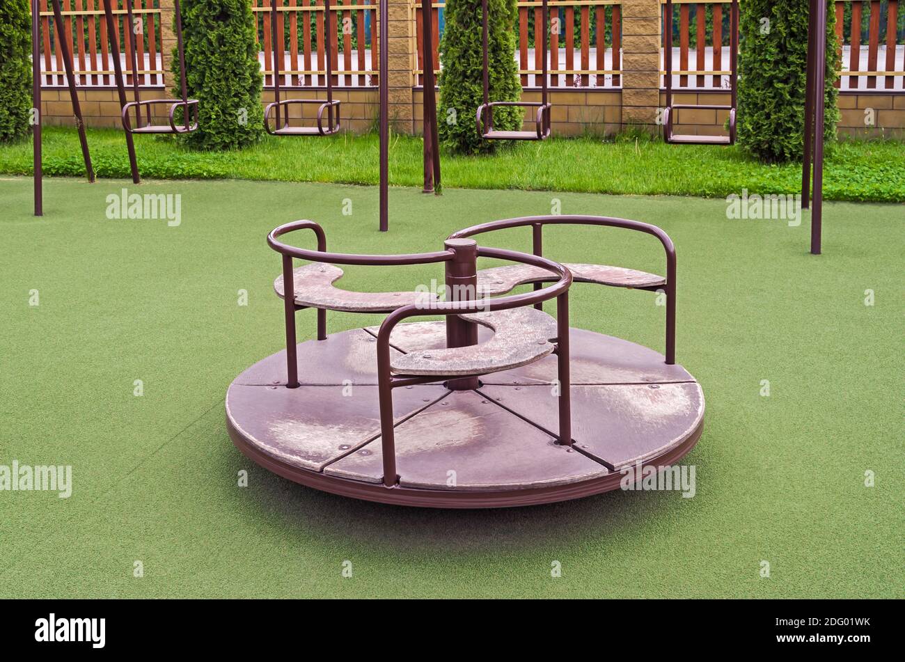 Rotazione childish swing sulla superficie anti-traumatica nel cortile di asilo Foto Stock