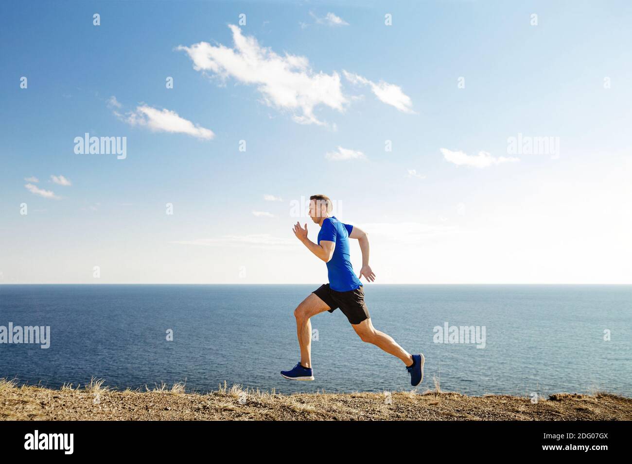 man runner maturo pista di corsa in sfondo cielo blu e. mare Foto Stock