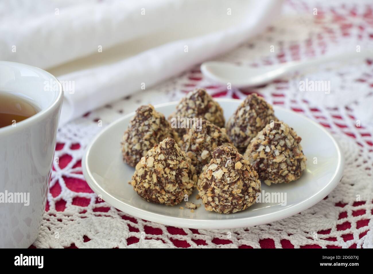 Tartufi fatti in casa con burro di arachidi, glassa di cioccolato e cialda su un tavolo con una tazza di tè, fuoco selettivo Foto Stock