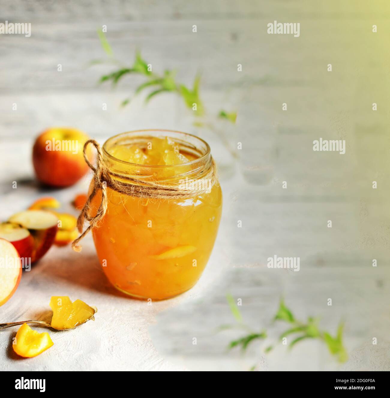 Marmellata di mele in un vaso di vetro trasparente. Marmellata di mele e arancio su uno sfondo chiaro. Deliziosa marmellata. Foto Stock